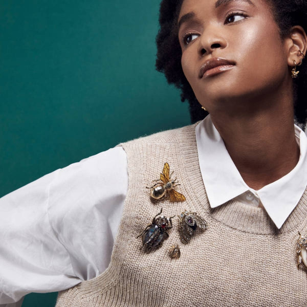 Model wearing multiple insect brooches including the Bill Skinner Bejewelled Beetle Brooch
